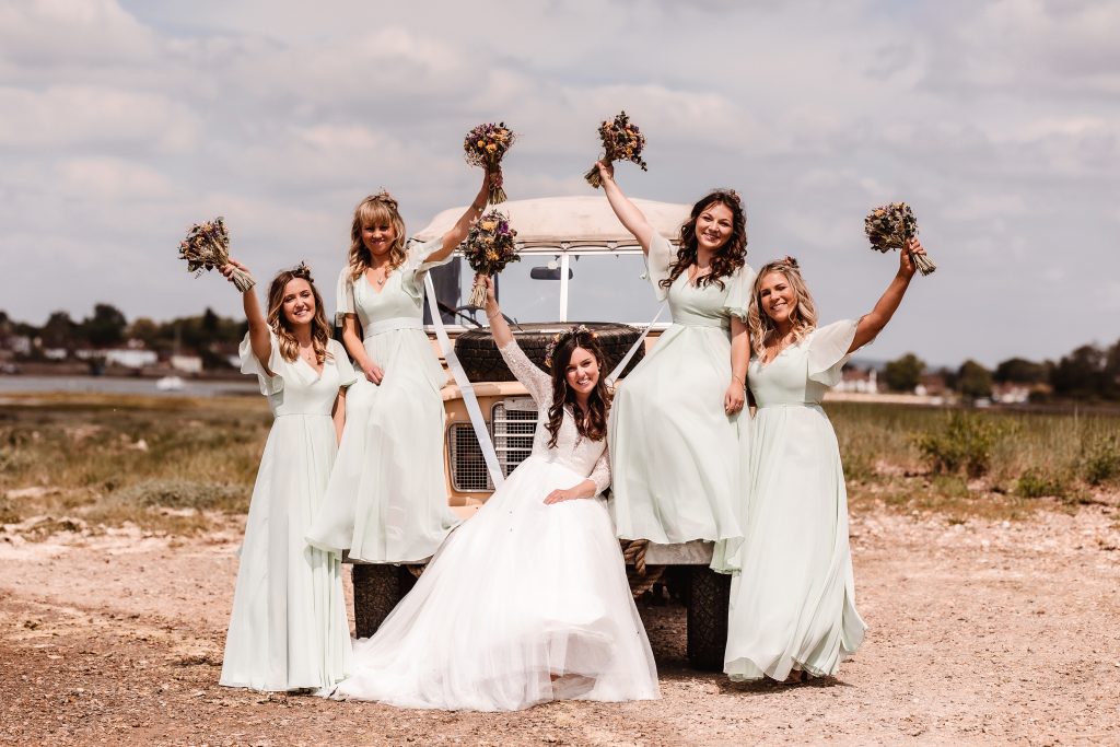 bride with bridesmaids by the car