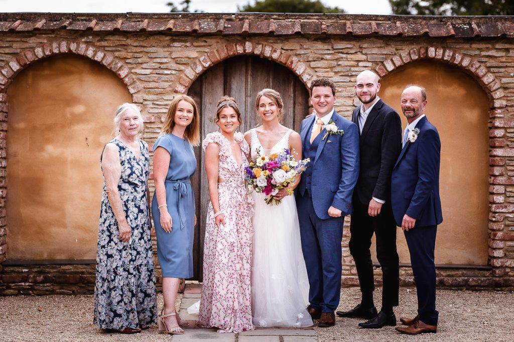 group wedding photo of bride and groom, parents and siblings