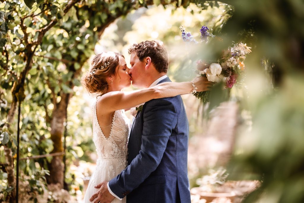 romantic photo of bride and groom kissing in the garden