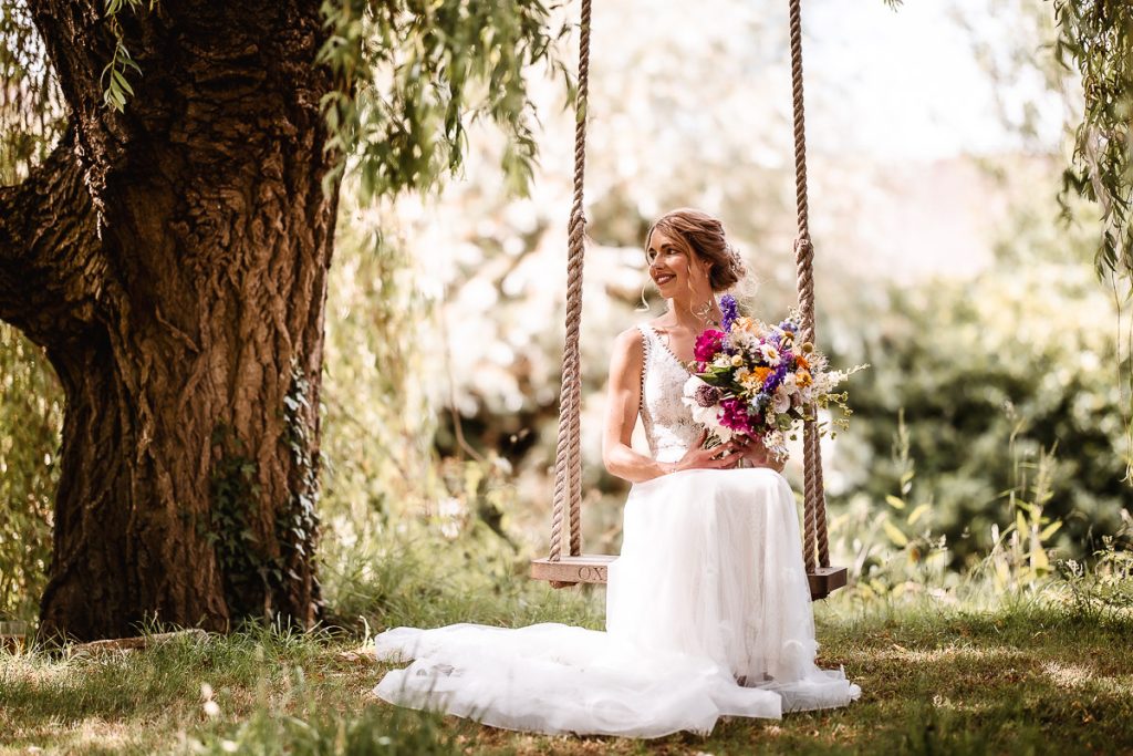 bride sitting on a swing under the tree