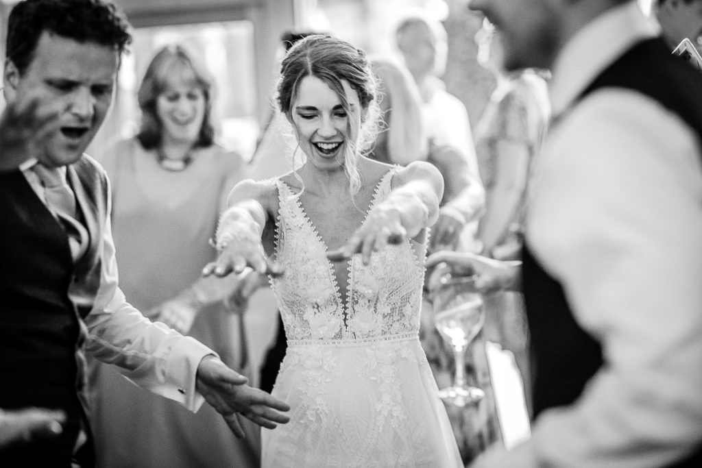 black and white photo of bride having fun and dancing