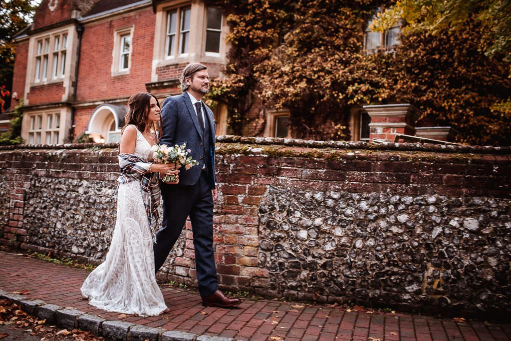 Bride and groom walking in the street. Autumn wedding at Hurley House Hotel, Berkshire