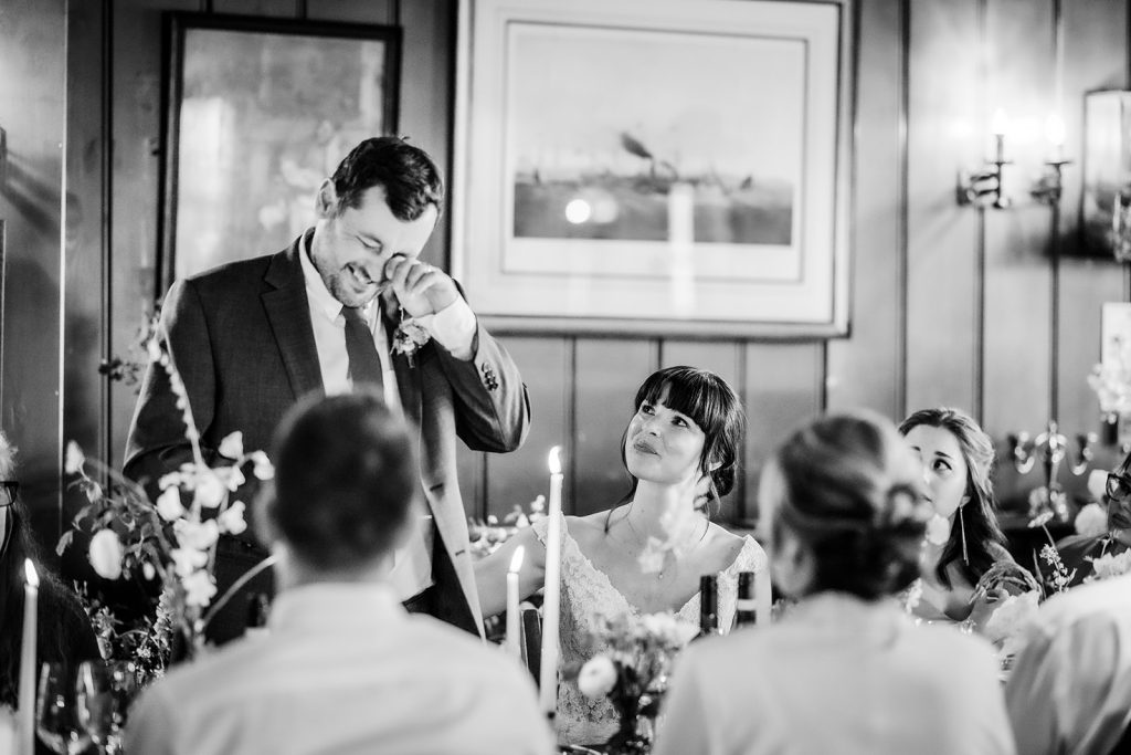 black and white photos of groom crying and feeling emotional during the wedding speech