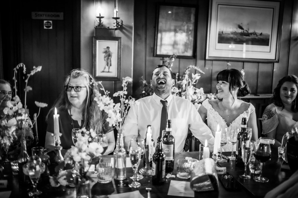 Candid photos of wedding couples laughing during the speech