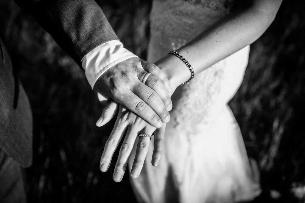 black and white wedding photo of couples' hands with rings