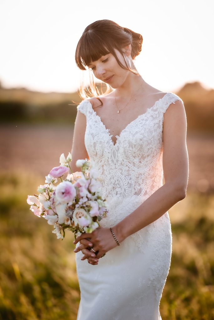 bride during the sunset holding her flowers bouquet