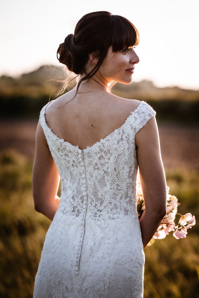 Natural and relaxed sunset photos of bride standing in the field