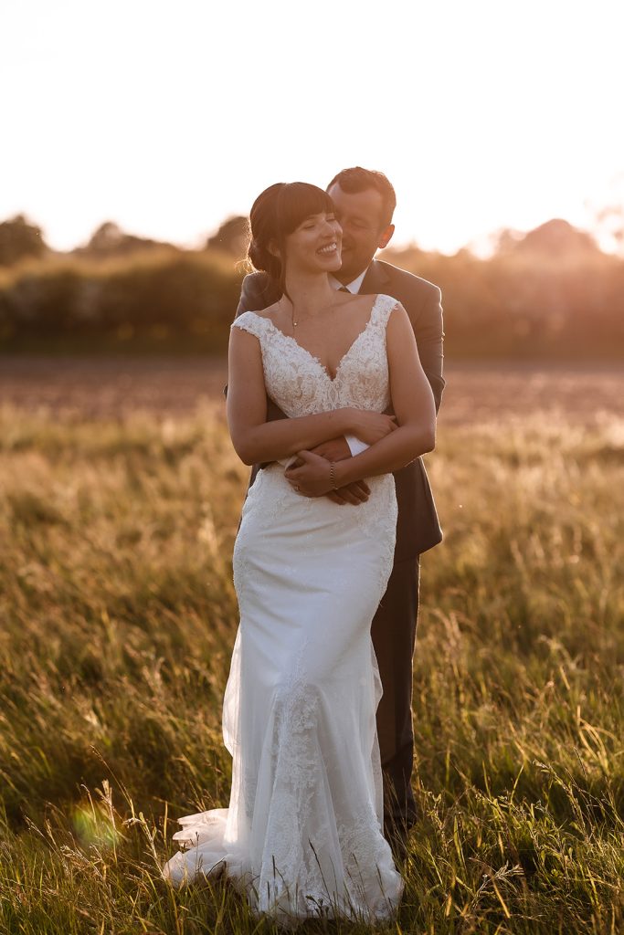 Sunset photos of bride and groom. Wedding couple during the golden hour