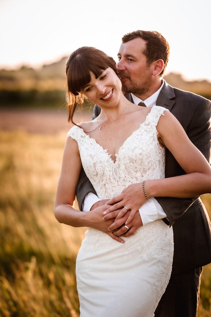 Sunset photos of bride and groom. Wedding couple during the golden hour