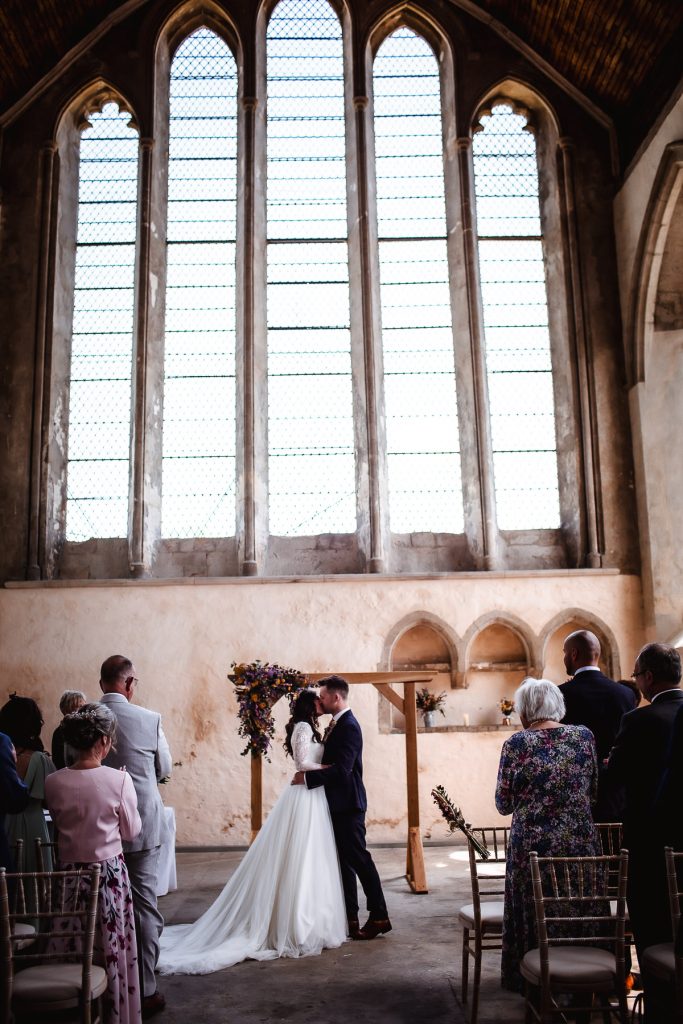 bride and groom's first kiss during the ceremony  in the church. Chichester wedding photographer