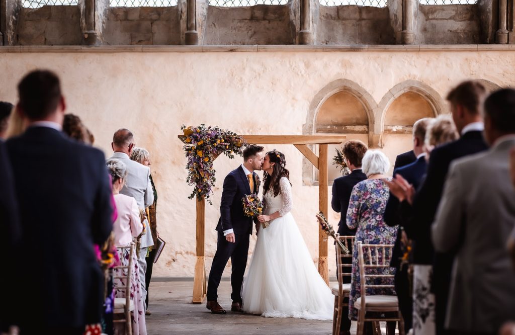 bride and groom are kissing at the church during the ceremony. First kiss at Guildhall, Chichester.