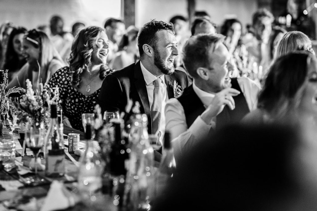 natural photos of wedding guests laughing and having fun during the speeches 