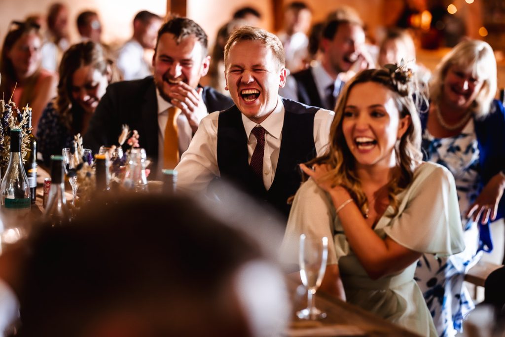 natural photos of wedding guests laughing and having fun during the speeches. West Sussex wedding photographer