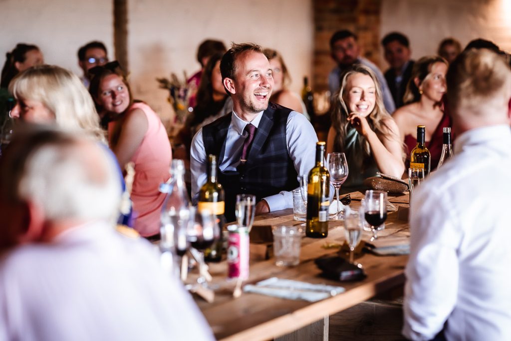 natural photos of wedding guests laughing and having fun during the speeches 