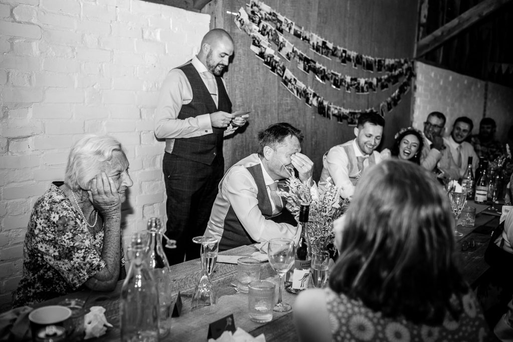 natural photos of wedding guests laughing and having fun during the speeches 