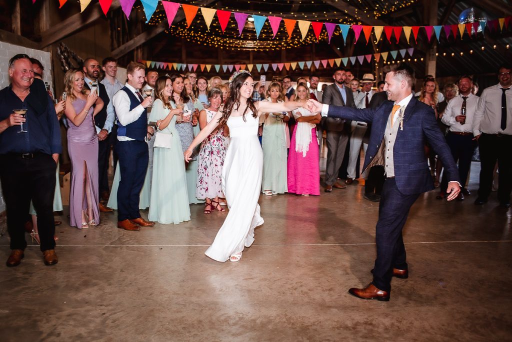 groom and bride's first dance in a wedding barn