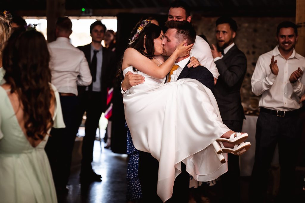 groom holding his bride and kissing at Chidham Barn Chichester