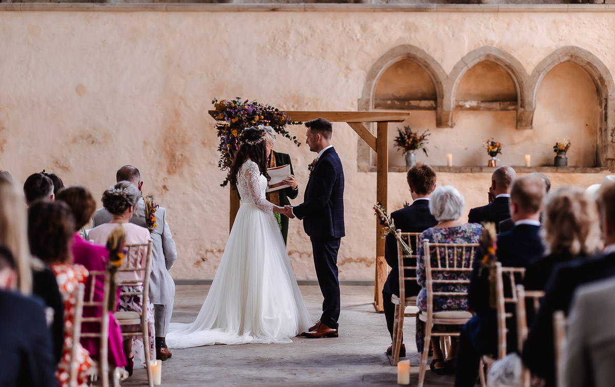 bride and groom holding hands during the wedding ceremony in the church Guildhall, Chichester, West Sussex wedding photographer