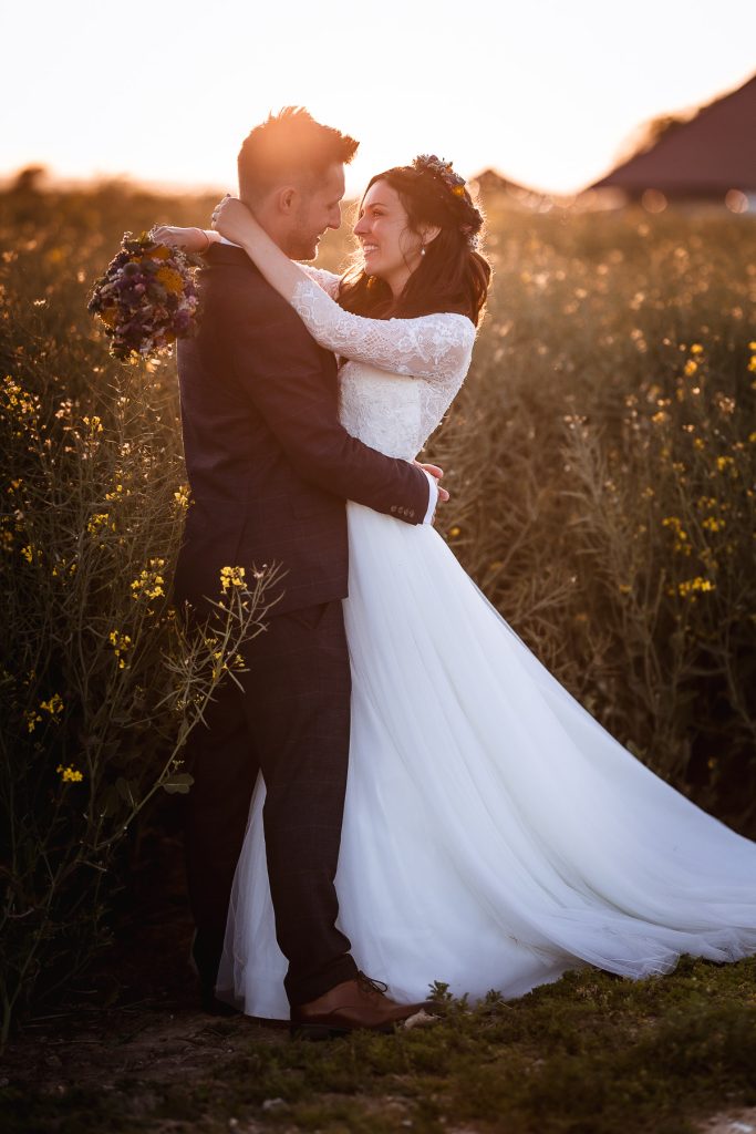 magical sunset photos of bride and groom in the field at Chidham Barn. West Sussex natural wedding photographer