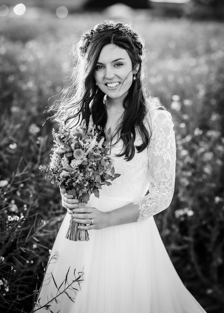 black and white magical sunset photos of bride in the field holding her flowers