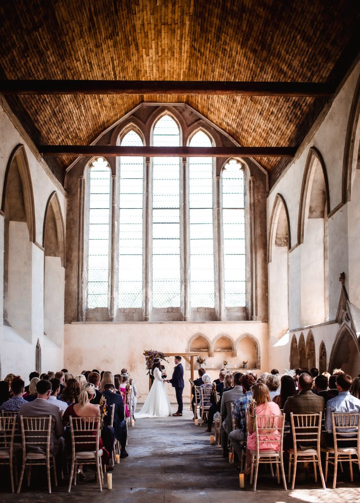 bride and groom holding hands during the wedding ceremony in the church Guildhall, Chichester wedding photography