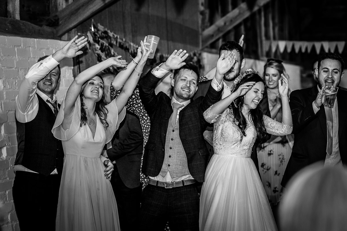 dance floor fun at the wedding bride and groom having a prosecco in the land rover at Chidham Barn