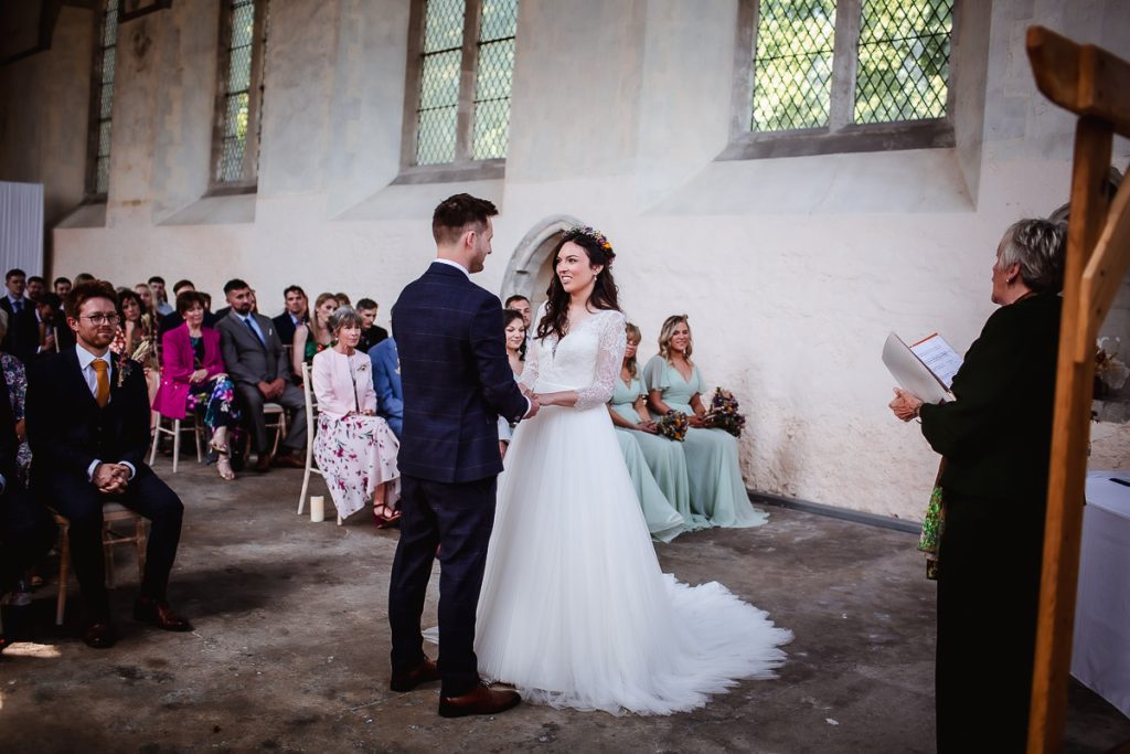 bride and groom holding hands during the wedding ceremony in the church Guildhall, Chichester wedding photographer