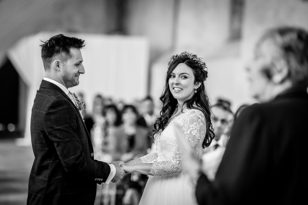 bride and groom holding hands during the wedding ceremony in the church Guildhall, Chichester wedding indoor ceremony