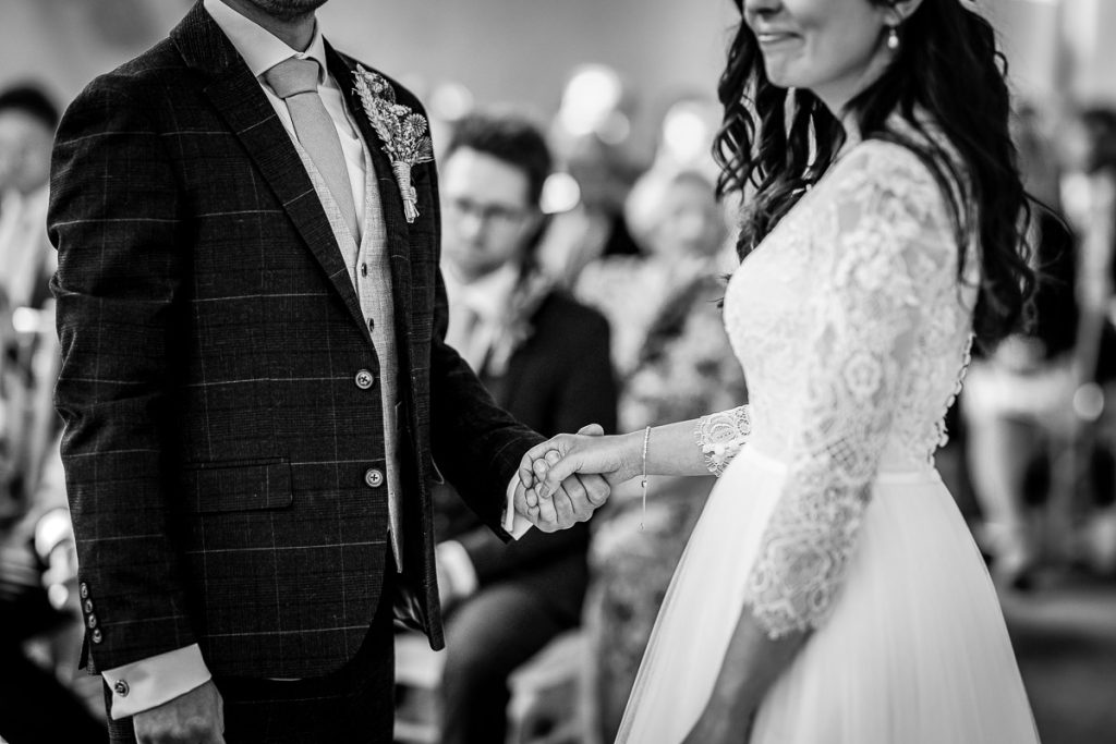 bride and groom holding hands during the wedding ceremony in the church Guildhall, Chichester wedding photography