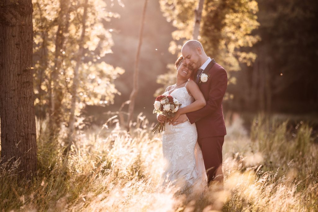 romantic sunset photo of bride and groom cuddling each other