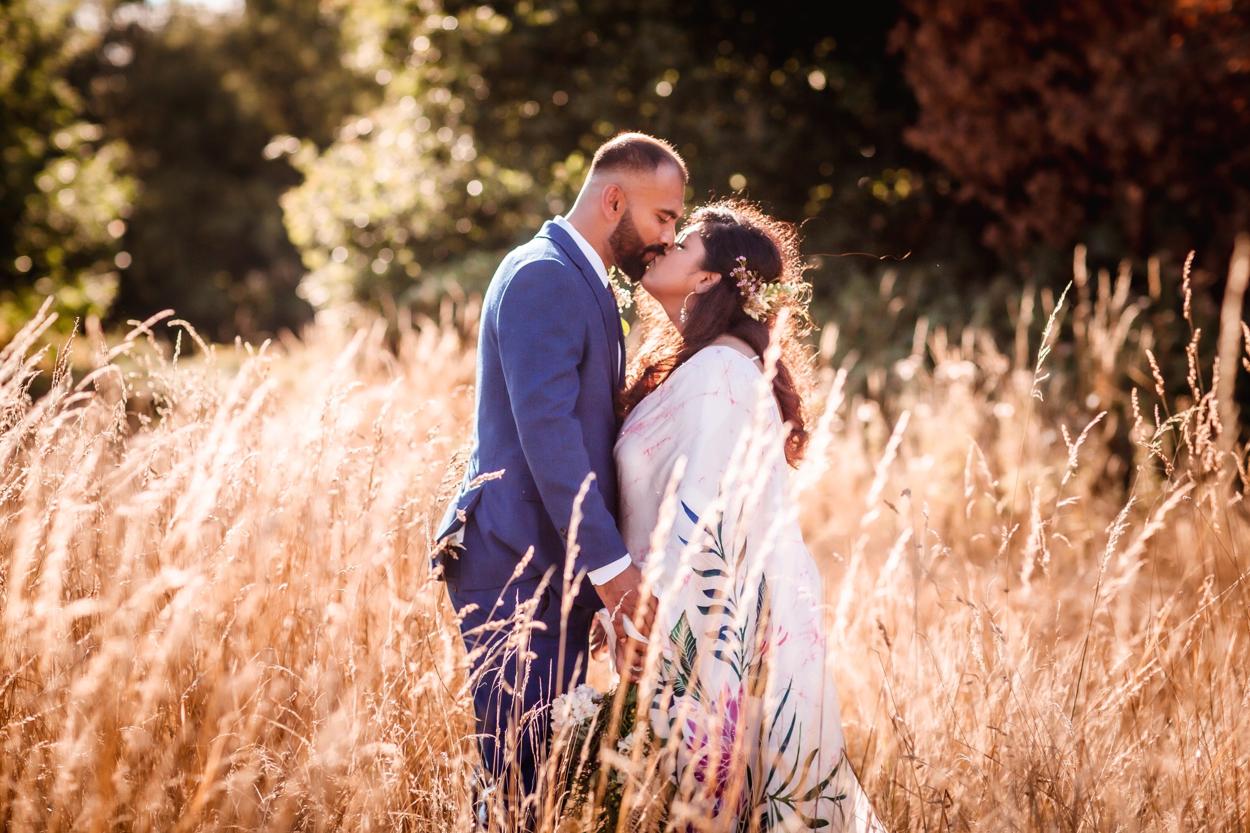 Sri Lanka wedding couple bride and groom kissing in the field with long grass. Surrey wedding photographer