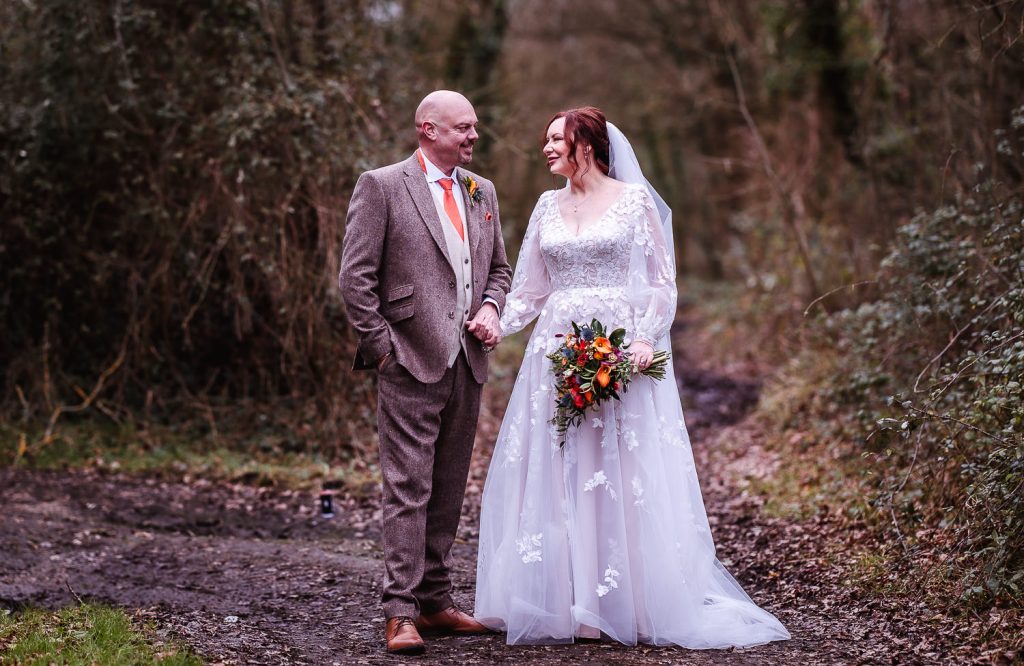 Bride and groom standing next to each other in the pathway at Skylark Hotel and Club, Hampshire