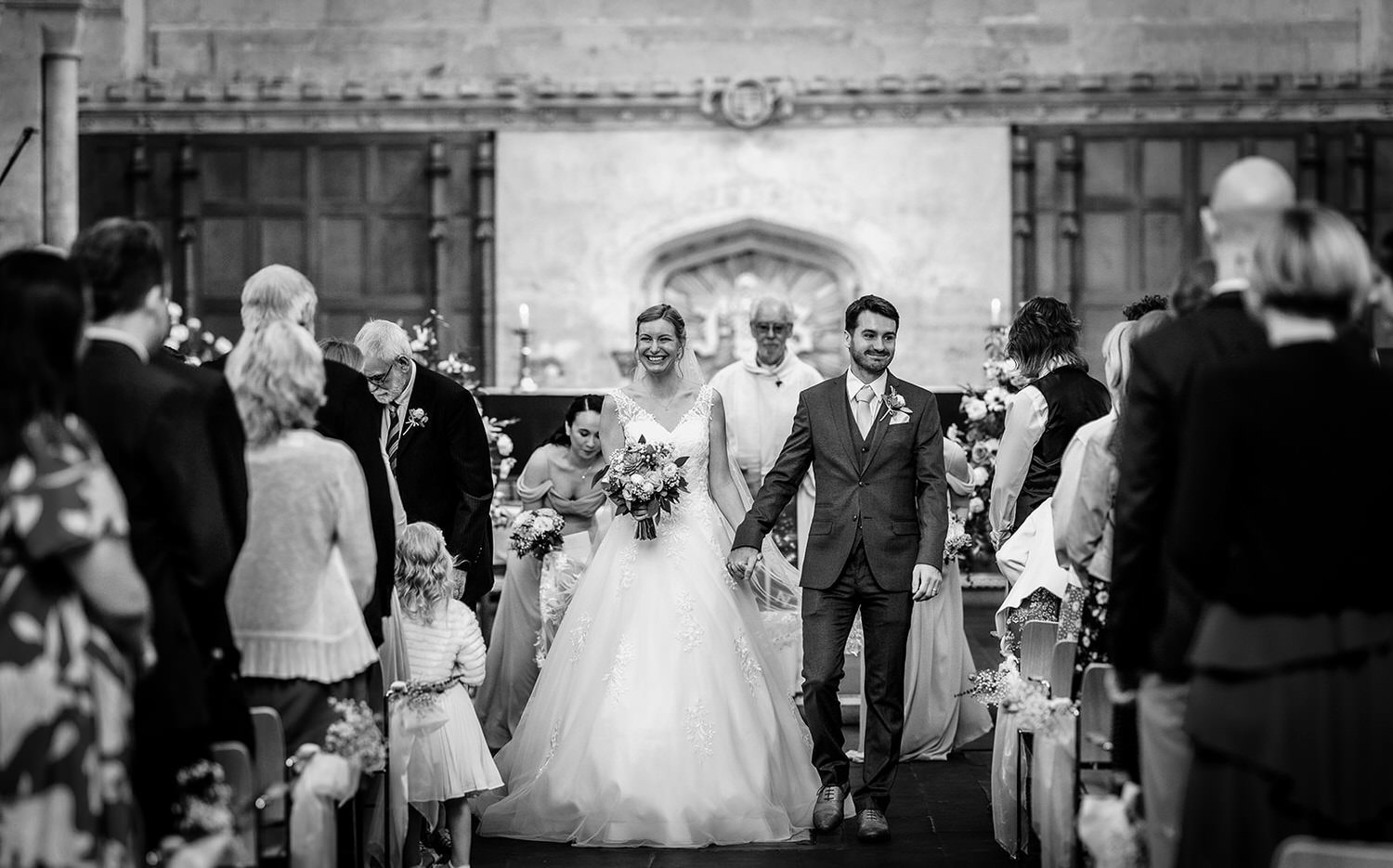 Ceremony photo at church. Bride and groom coming down the isle at Malmesbury Abbey