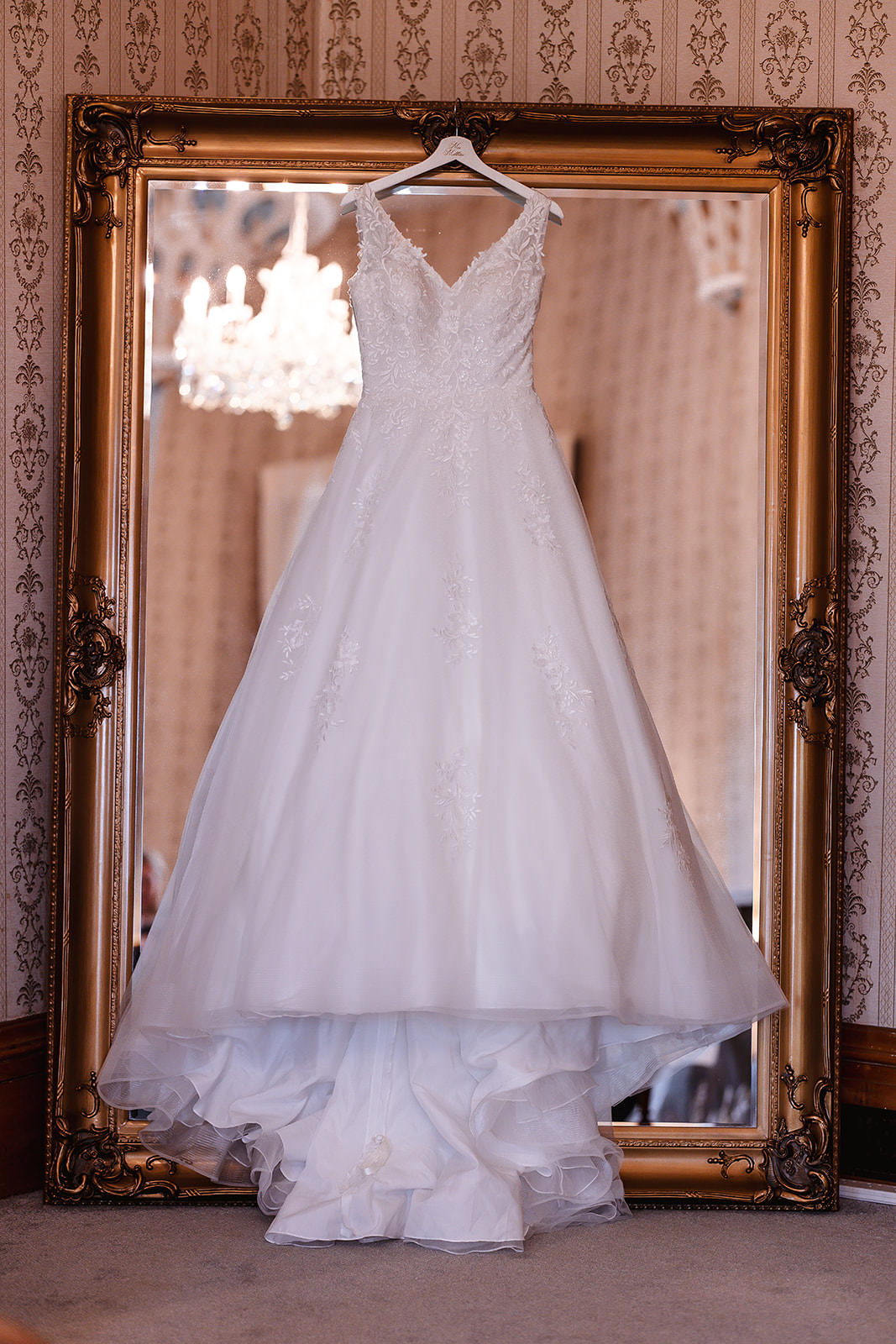 white wedding dress hanging on the big mirrow at Grittleton House in Cotswold