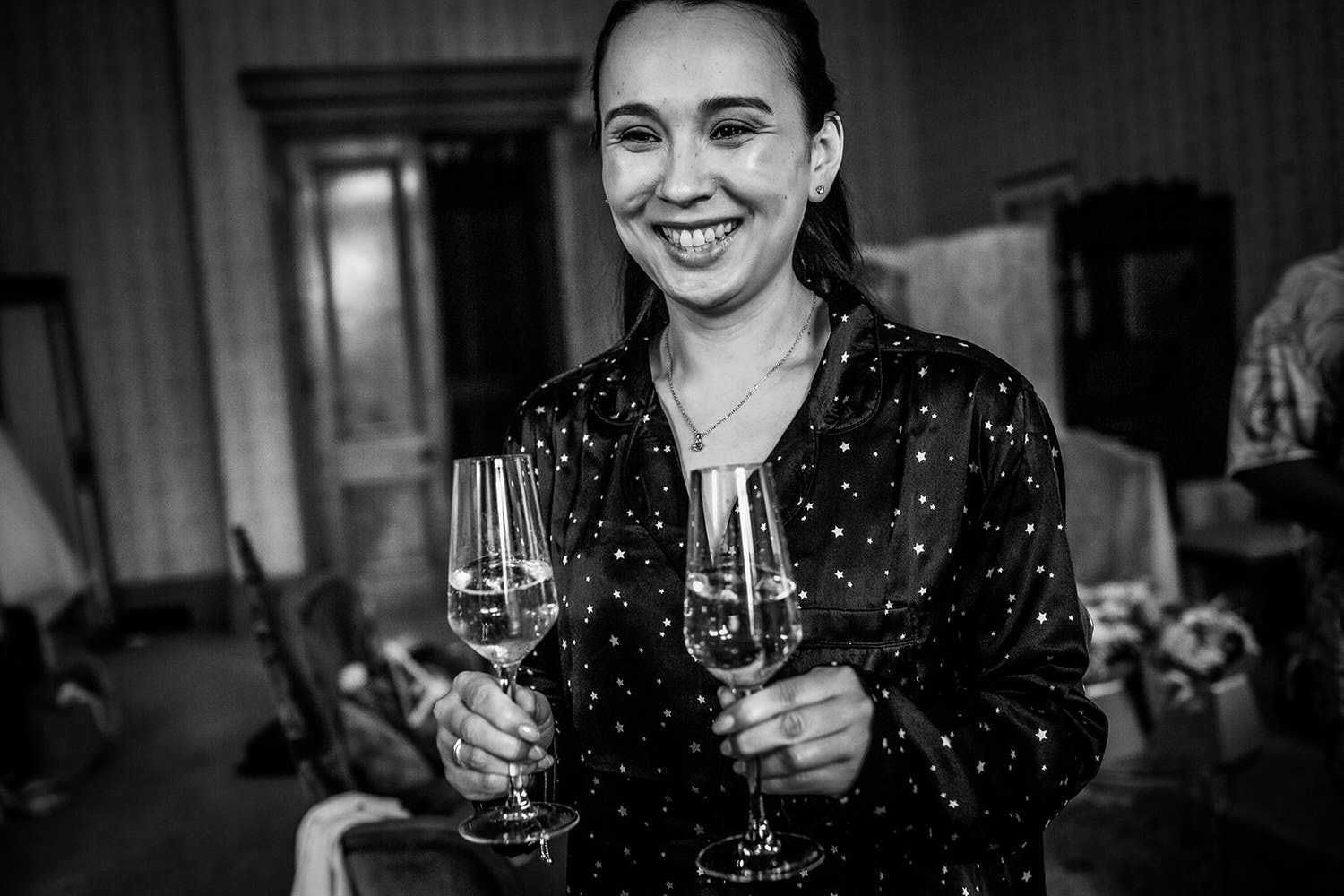 photo of bridesmaid holding glasses of prosecco during the bridal preparation at Wiltshire wedding venue at Grittleton House