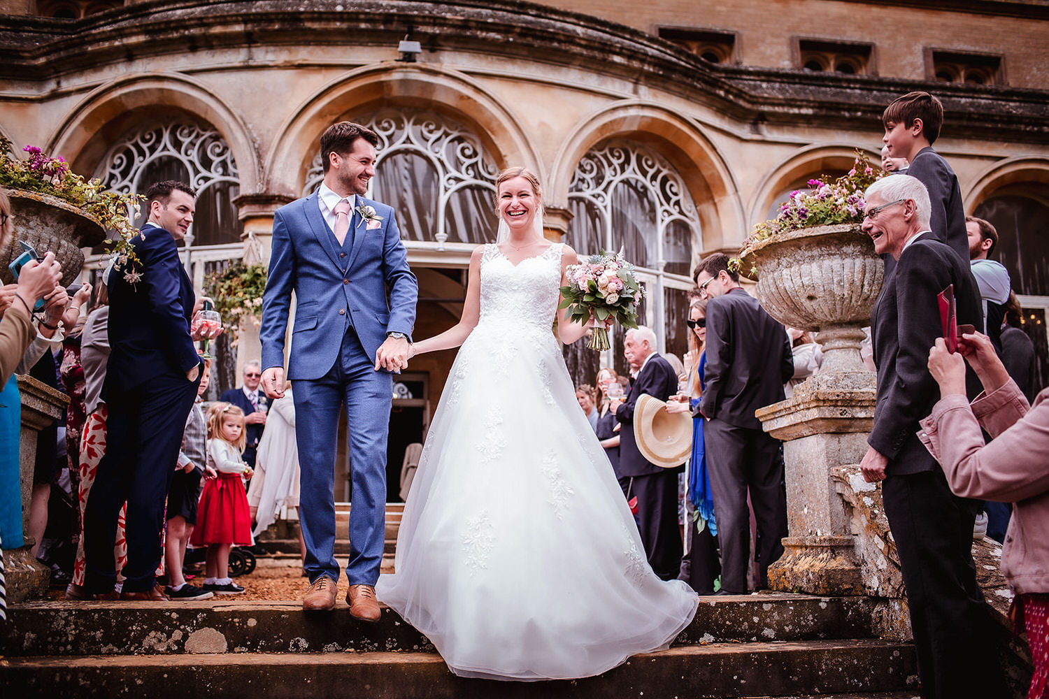 Confetti photo of bride and groom leaving a church Malmesbury Abbey in Wilthsire