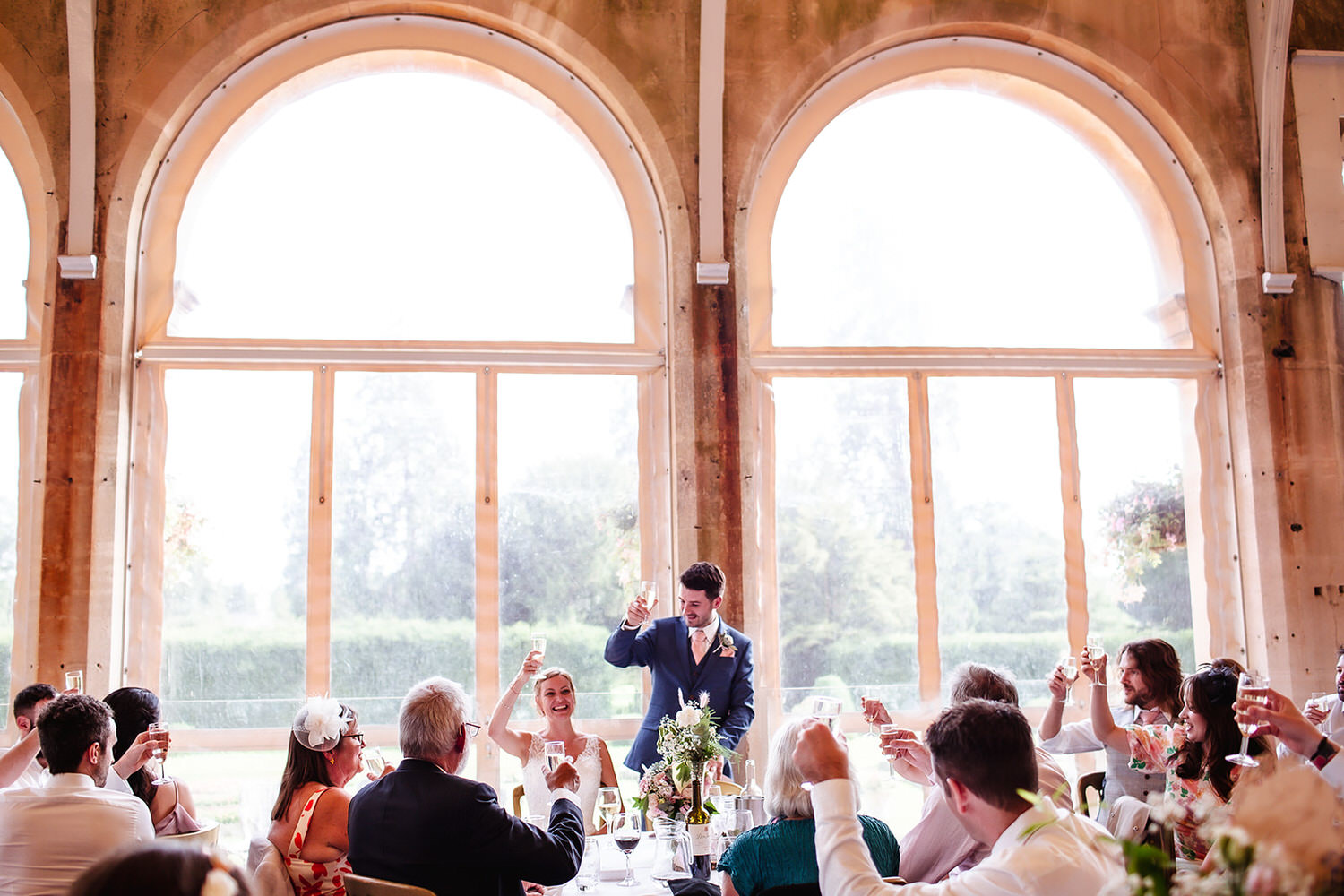 bride and groom raising their glasses for toast at Grittleton House