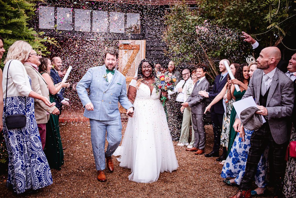 colourful confetti photo of bride and groom at Surrey wedding venue High Billinghurst Farm