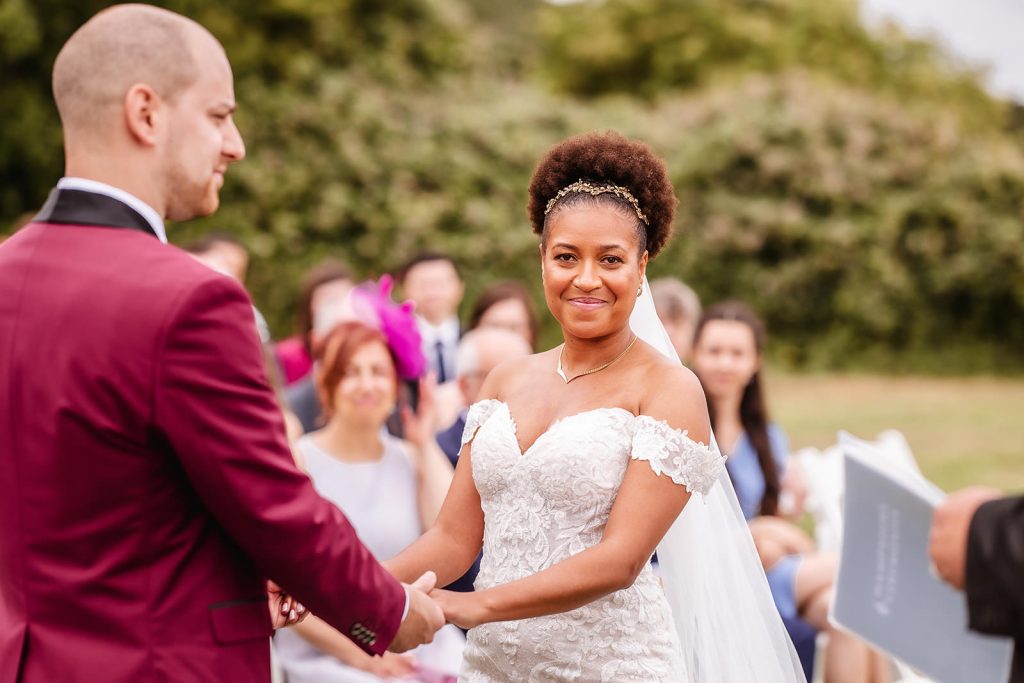 bride's happy face during an outdoor wedding ceremony at Tournerbury Woods Estate. Hampshire wedding photographer