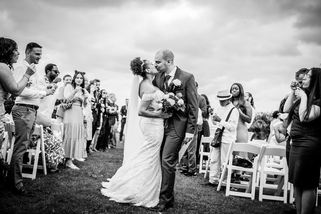 bride and groom kissing when leaving their wedding ceremony at Tournerbury Woods Estate