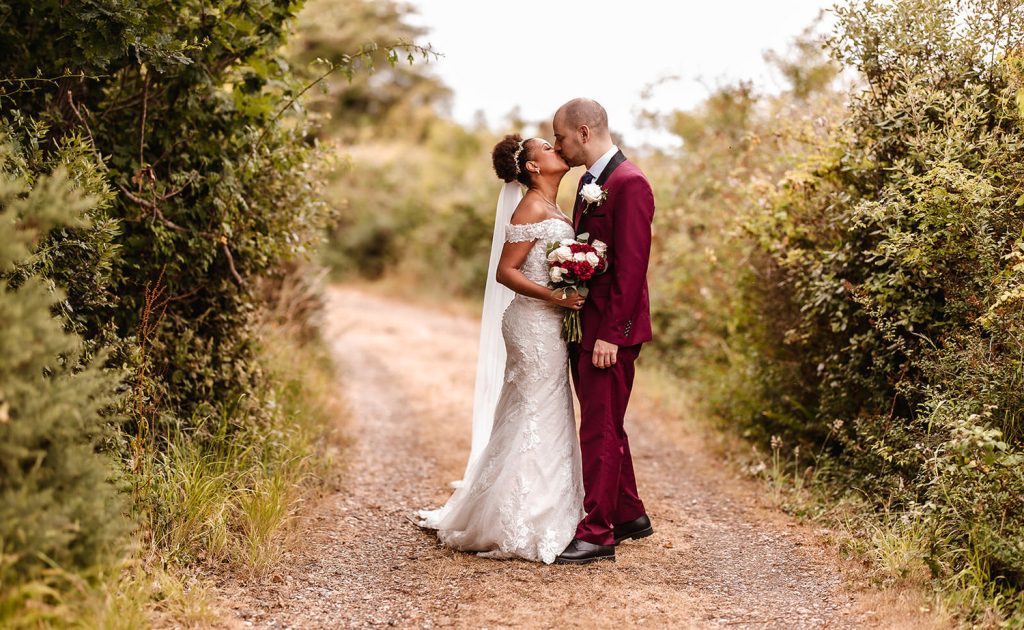 bride and groom kissing on the pathway at Tournerbury Woods Hampshire.