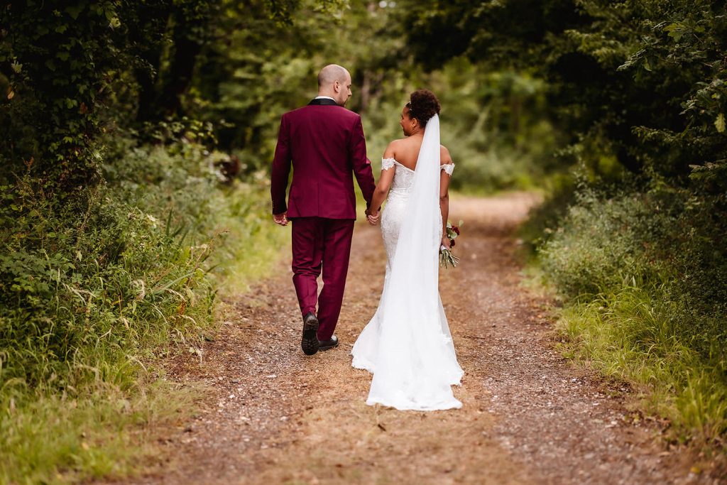 bride and groom walking on the pathway in woods in Hayling Island.