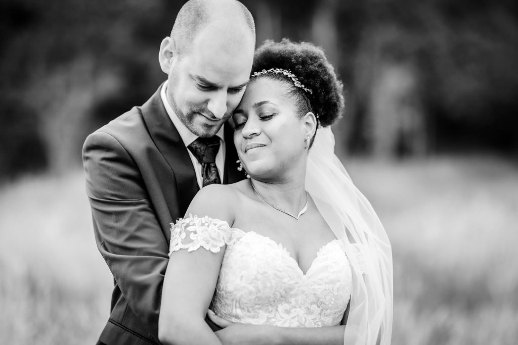 bland and white wedding photo of bride and groom cuddling each other at Tournerbury Woods