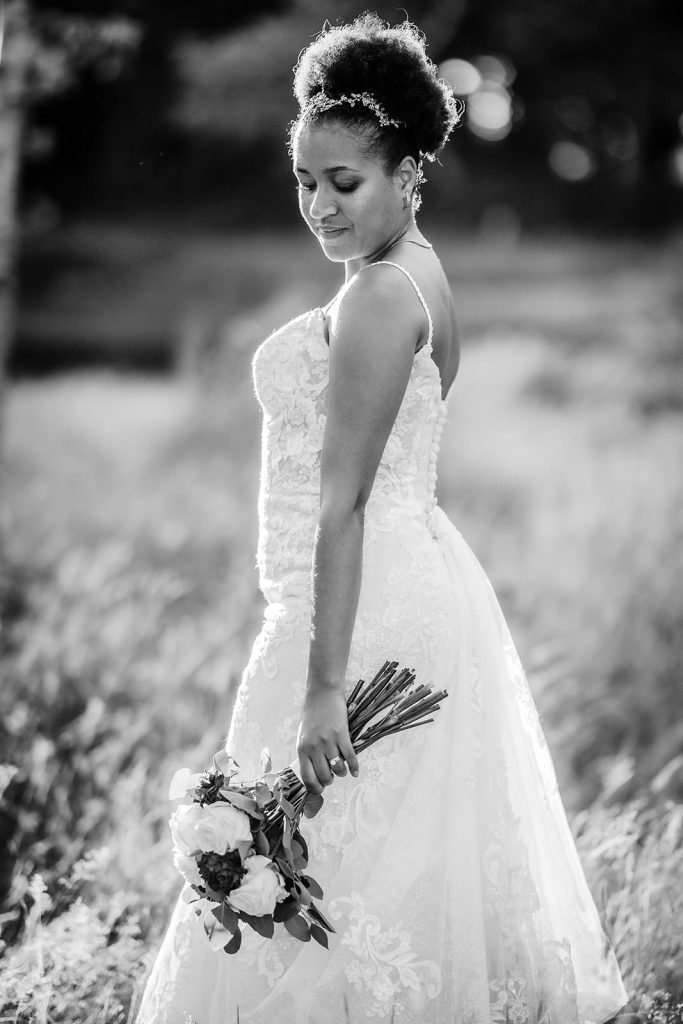 black and white portrait photo of bride holding her wedding flowers at Hampshire outdoor wedding venue