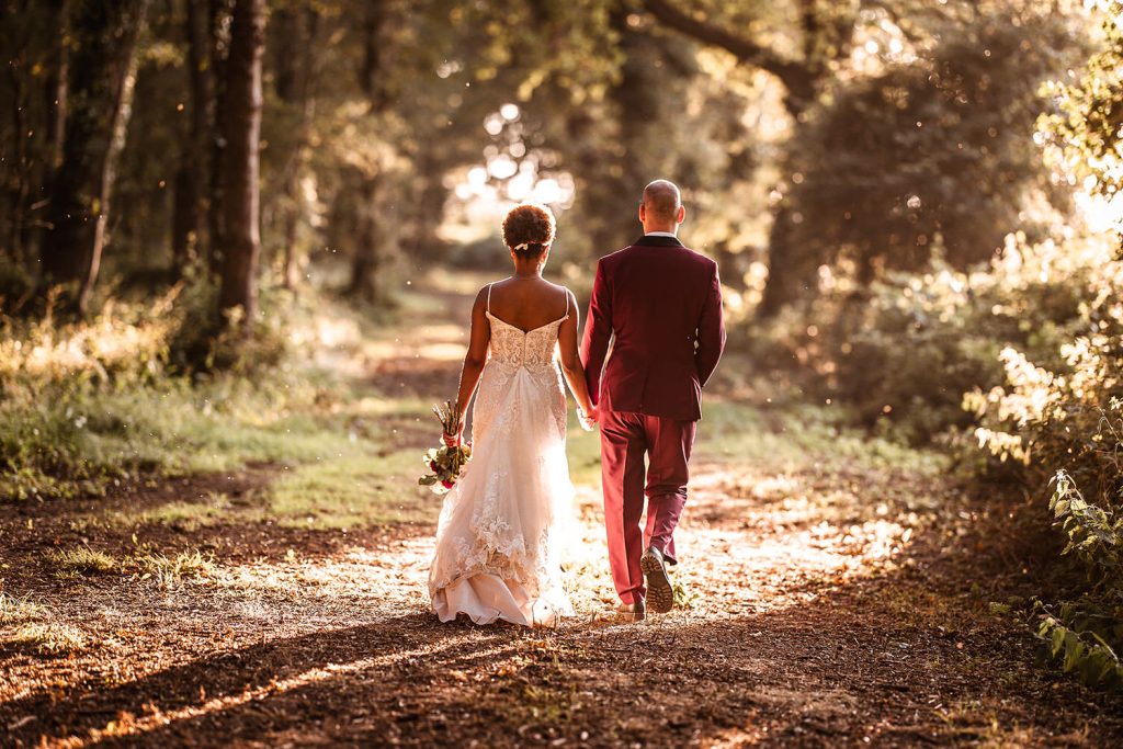 Sunset photo of bride and groom walking hand in hand in the woods of Tournerbury, Hayling Island