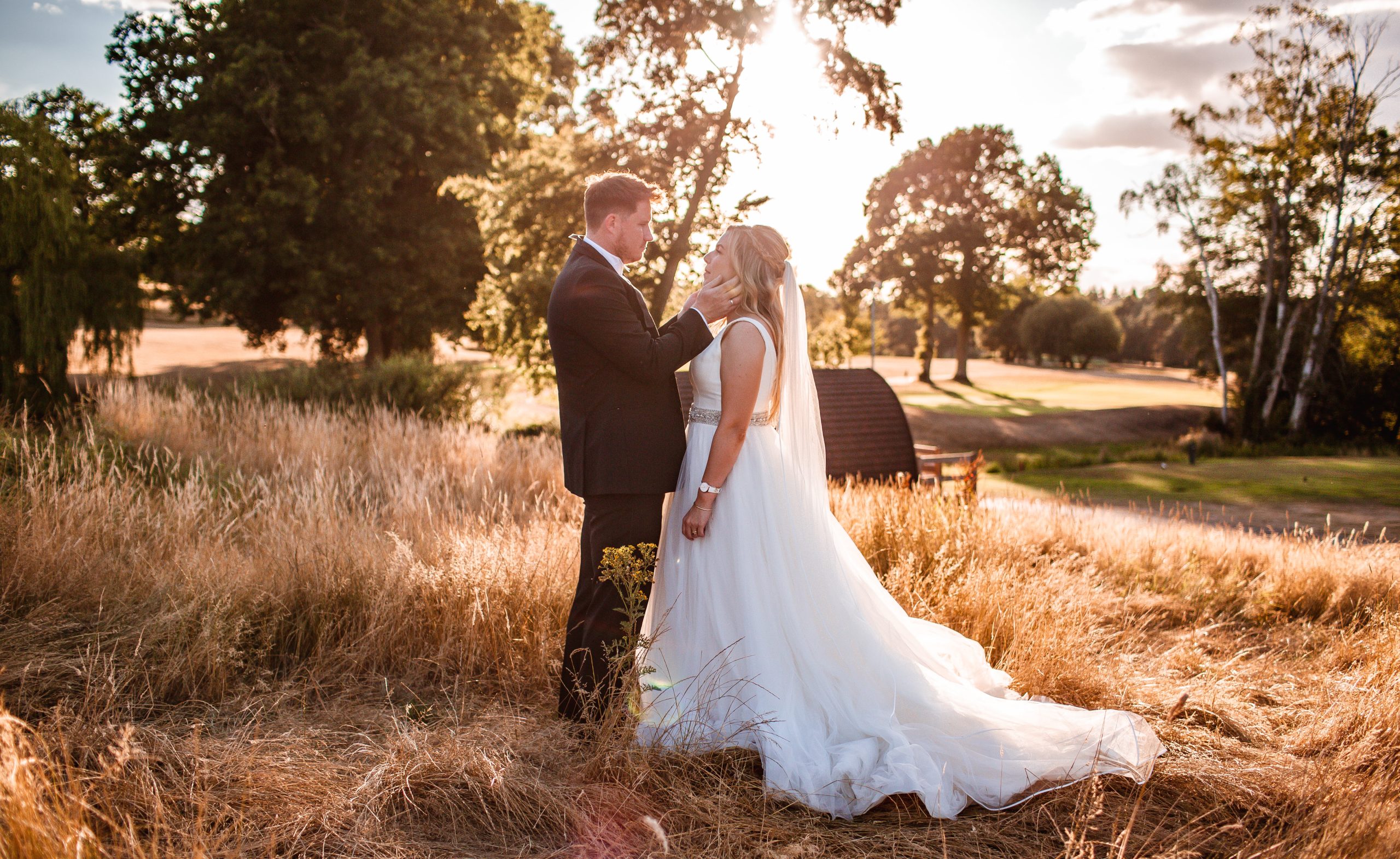 Summer sunset photo of bride and groom in the field at Old Thorne Liphook, Hampshire wedding photography