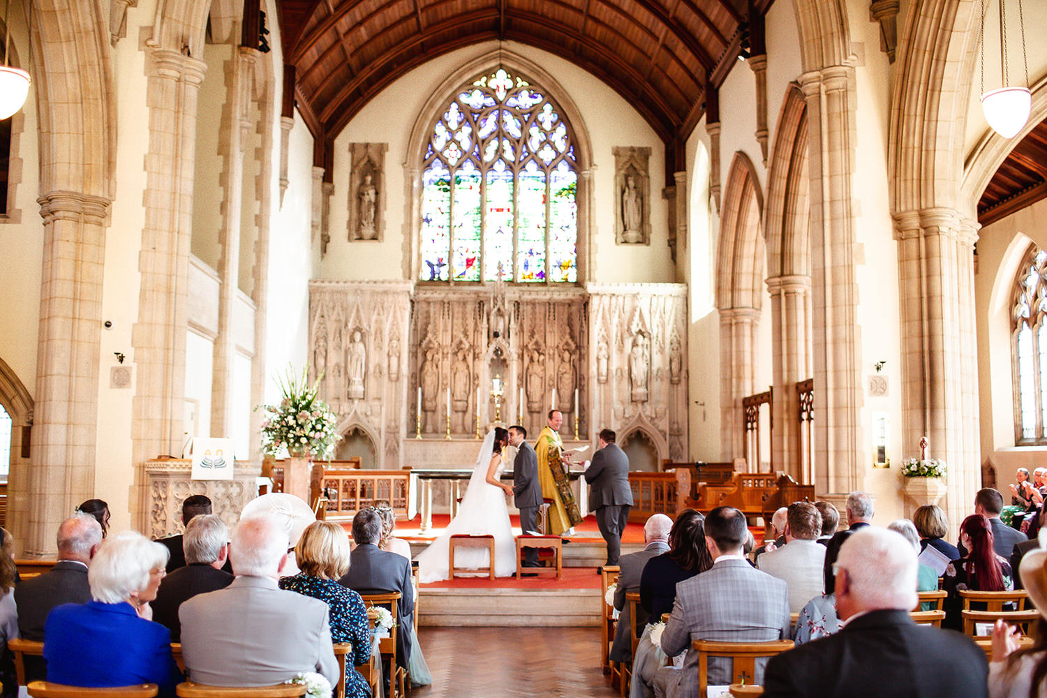 First kiss of bride and groom at the church ceremony at St Peters Churchc in Winchester