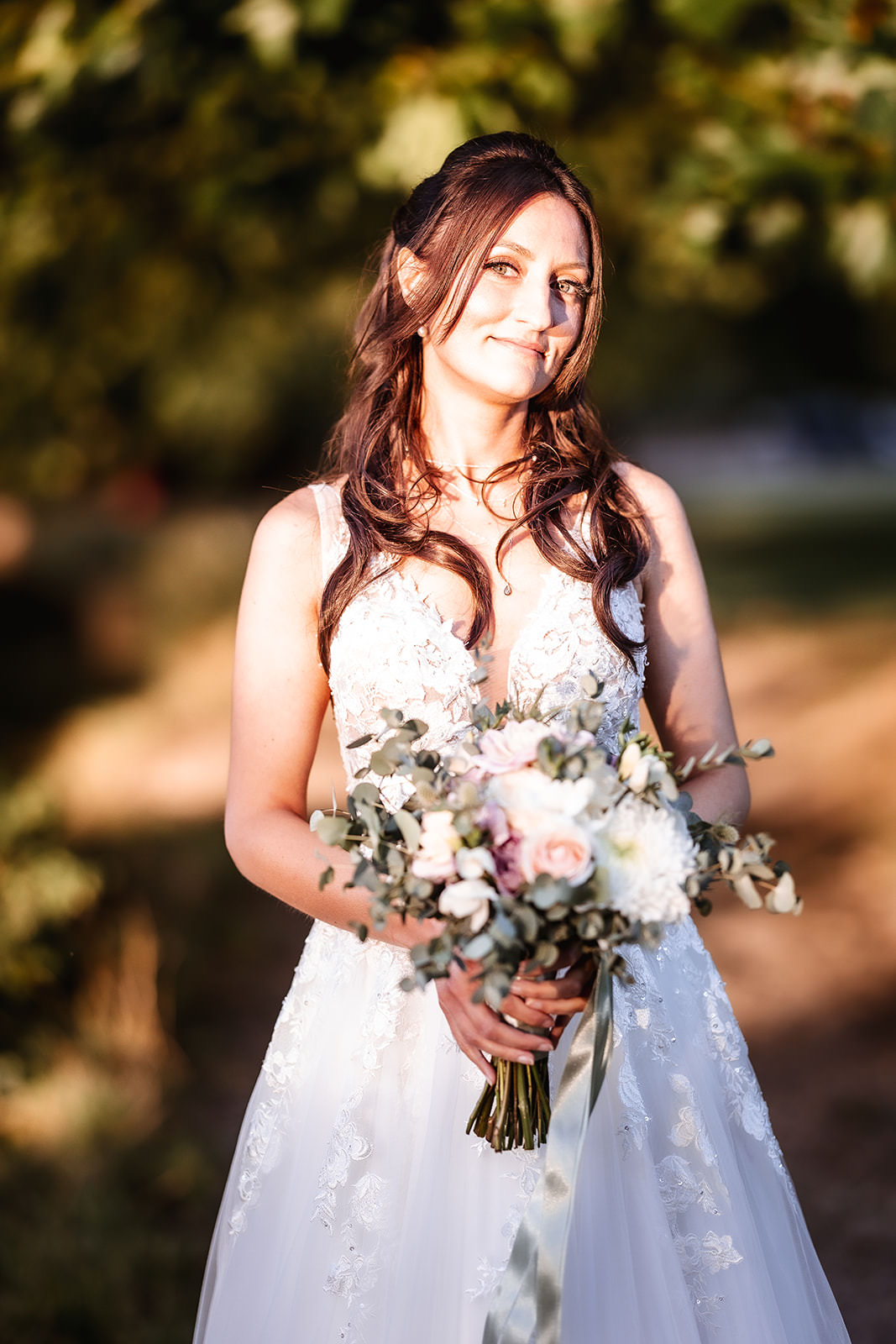 Sunset photo of bride holding her flowers outside in the park in Chichester