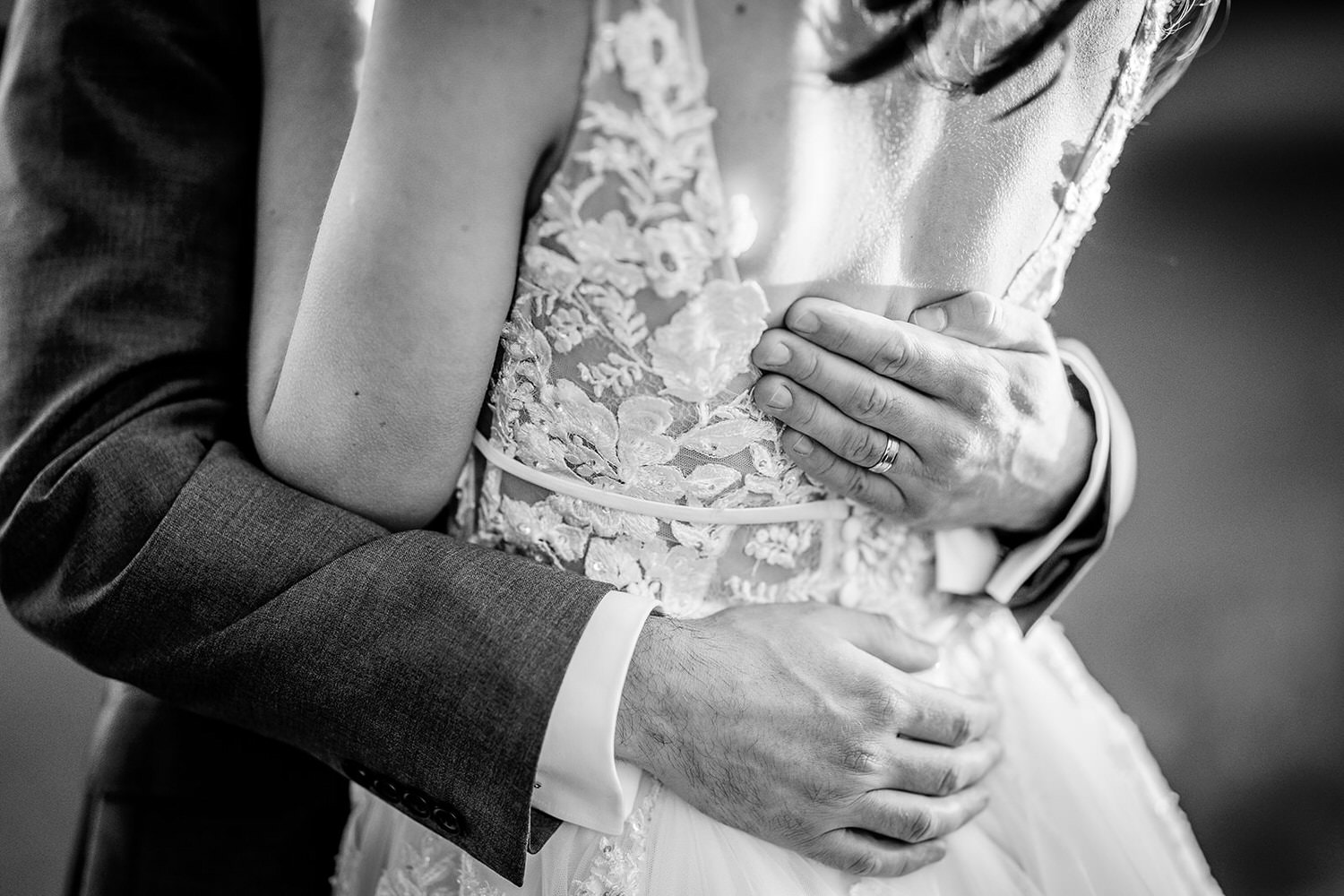 groom's details of the ring and holdidng his bride