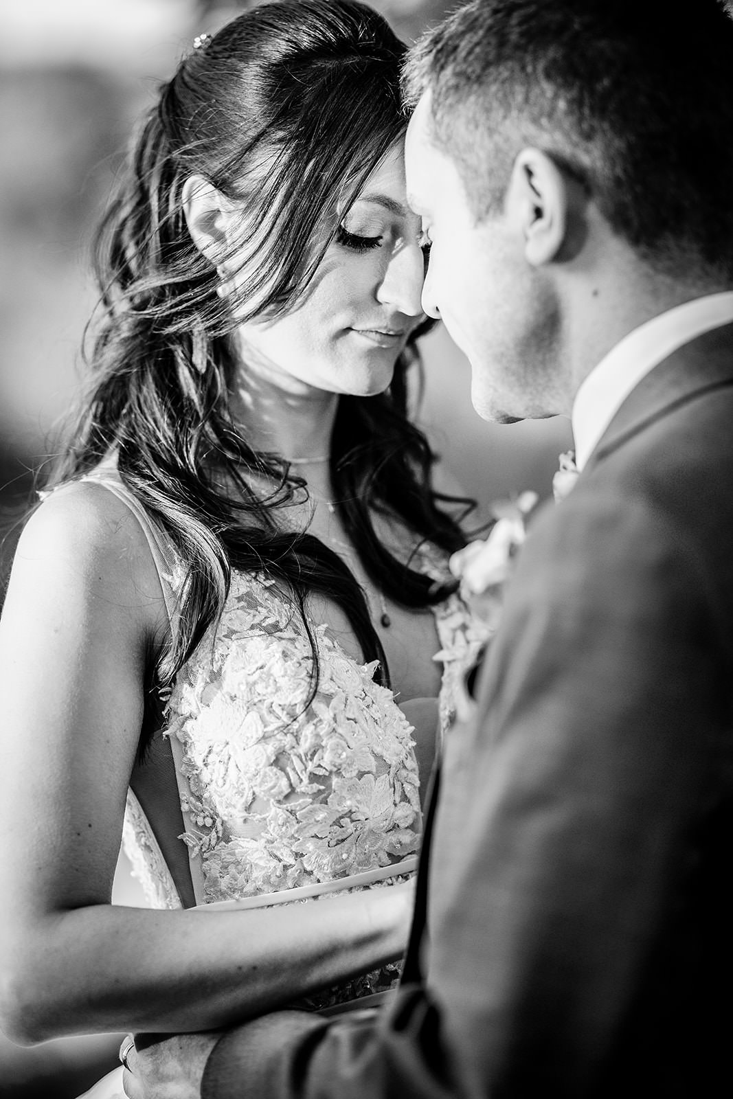 black and white photo of bride and groom touching their forheads